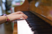 the hands of a piano playing kid in a funny mood.